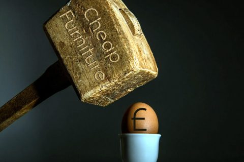 Mallet beating pound symbol on an egg.