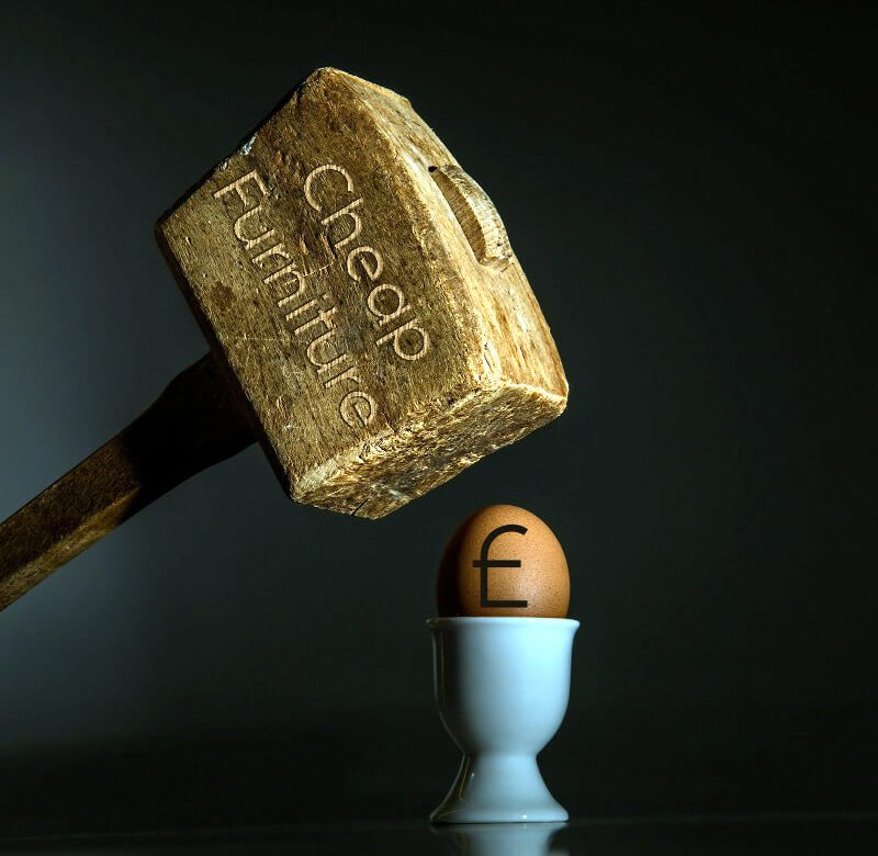 Mallet beating pound symbol on an egg.