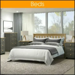 A bedroom scene, with various pieces of matching furniture. The room has a very large window behind the bed.