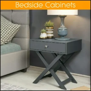A blue bedside cabinet sitting beside a bed. The cabinet legs are in an X style, and there's a lamp and some pot plants on top of it.