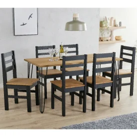 A pine and black dining set in a kitchen area. It's a large table and there's 6 matching chairs.