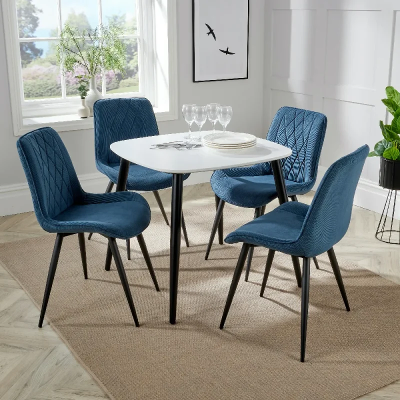 Stylish modern dining set featuring a round white table and four blue upholstered chairs with black legs, ideal for contemporary interiors.
